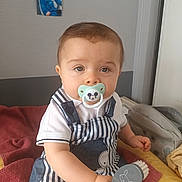 Nino a rejoint le concours — aidez-le/la à gagner de superbes lots ! baby, bed, blanket, brush, child, clothing, cute, furniture, hairbrush, indoor, mickey_mouse, pacifier, pacifier_holder, person, photo_frame, plush, smiling, striped_overalls, toddler, wall