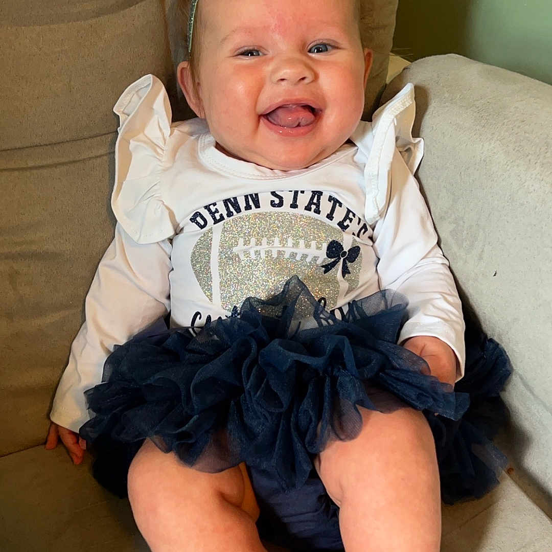 Mila joined the competition — help win amazing prizes! baby, babylaughing, clothing, costume, couch, cushion, dress, face, furniture, happy, head, homedecor, laughing, pants, person, photography, portrait, shorts, sitting, t_shirt