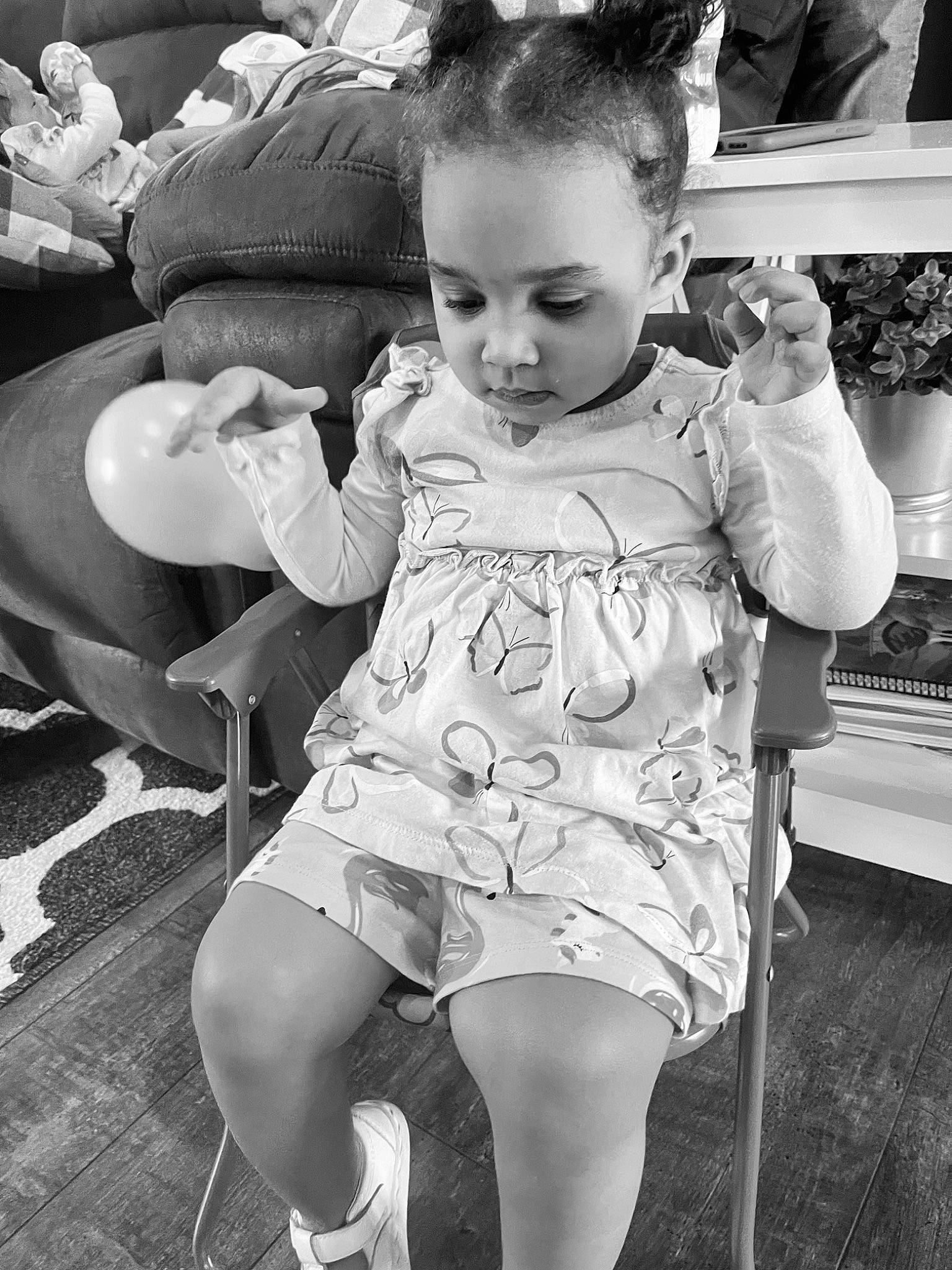 Zyla is registered to the contest to win money with this photo: baby, baby_toddler_clothing, black, black_and_white, chair, child, flash_photography, hairstyle, happy, human_leg, leg, monochrome, monochrome_photography, people, person, photograph, snapshot, style, thigh, toddler