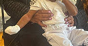 Jace joined the competition — help win amazing prizes! adult, baby, cap, caregiver, chair, child, face, family, hat, held, indoor, infant, mitten, pants, portrait, sitting, smiling, striped_shirt, white_clothing, wooden_floor