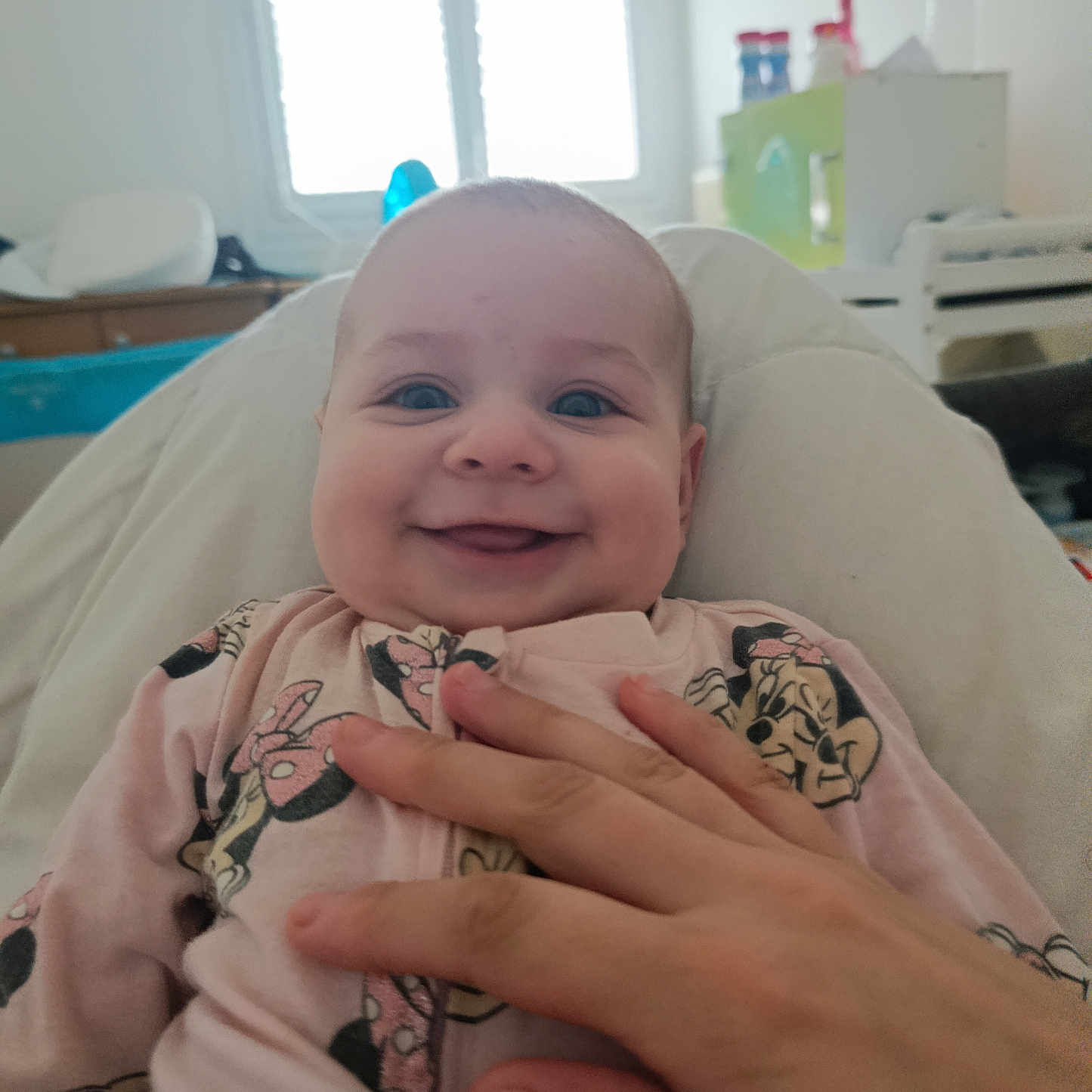 éléanore a rejoint le concours — aidez-le/la à gagner de superbes lots ! baby, smile, hand, clothing, person, indoor, window, furniture, bed, cute, infant, happy, face, portrait, child, room, soft_lighting, onesie, mickey_mouse, relaxing