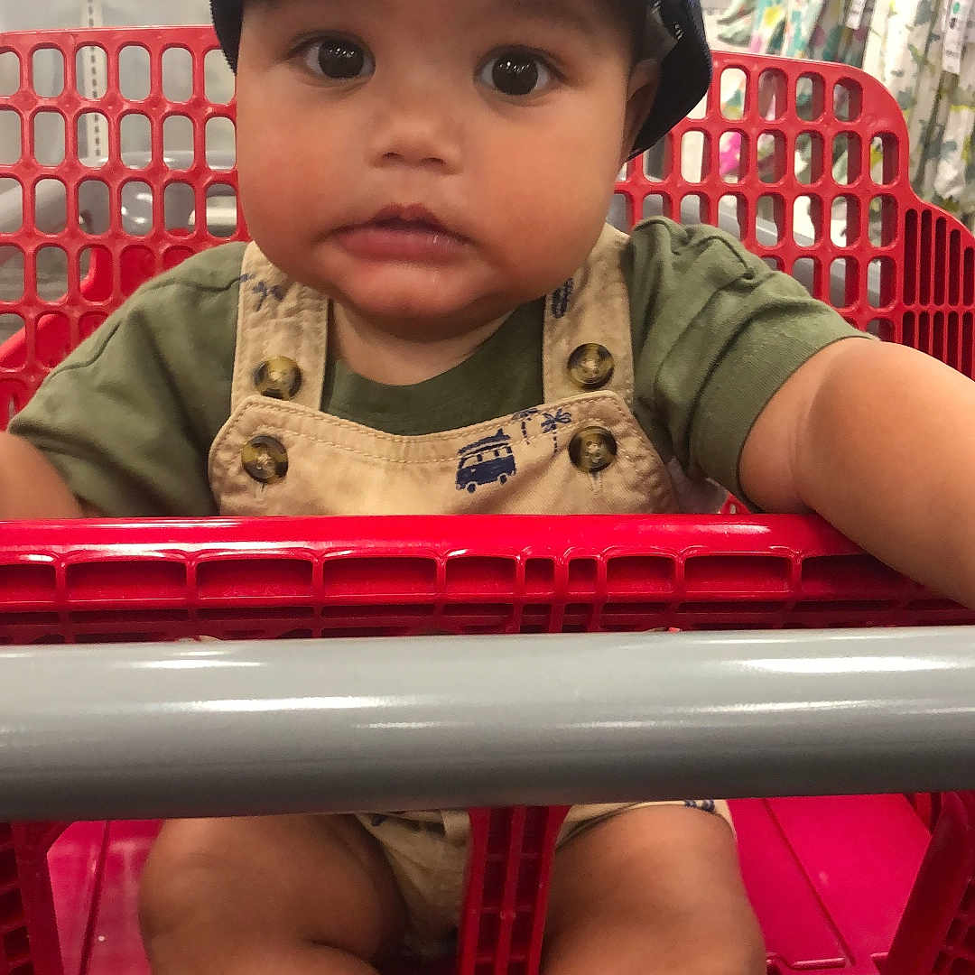 Kristopher is registered to the contest to win money with this photo: baby, baseballcap, basket, cap, city, clothing, crib, face, furniture, hat, head, infantbed, person, photography, playarea, portrait, road, shopping, shoppingbasket, shoppingcart