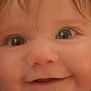 Sophie is registered to the contest to win money with this photo: baby, close_up, face, eyes, smile, infant, child, skin, hair, expression, cute, portrait, young, person, cheeks, nostrils, mouth, eyebrows, innocence, curiosity