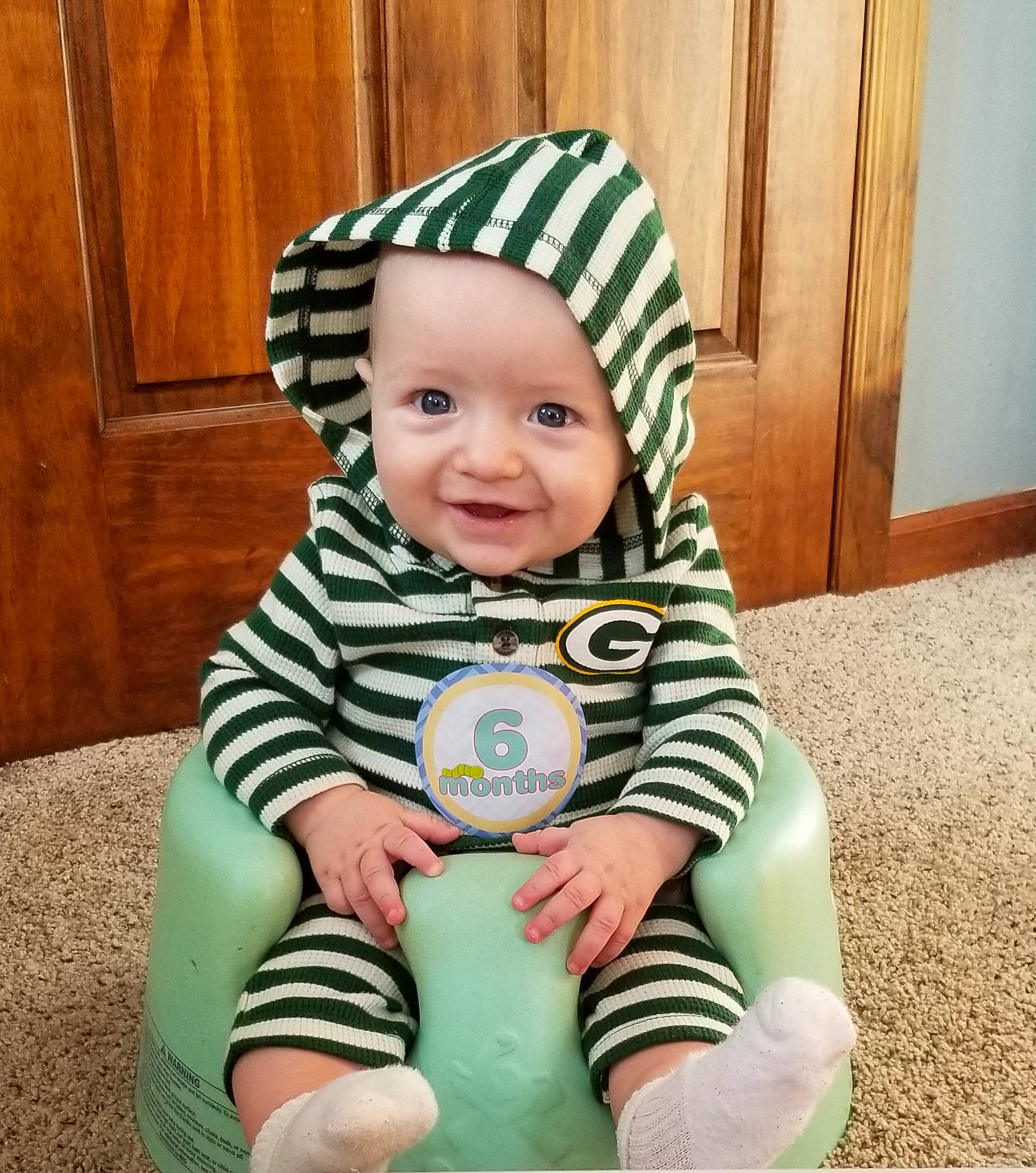 Theodore is registered to the contest to win money with this photo: baby, baby_products, baby_toddler_clothing, child, green, headwear, joy, person, play, sitting, toddler