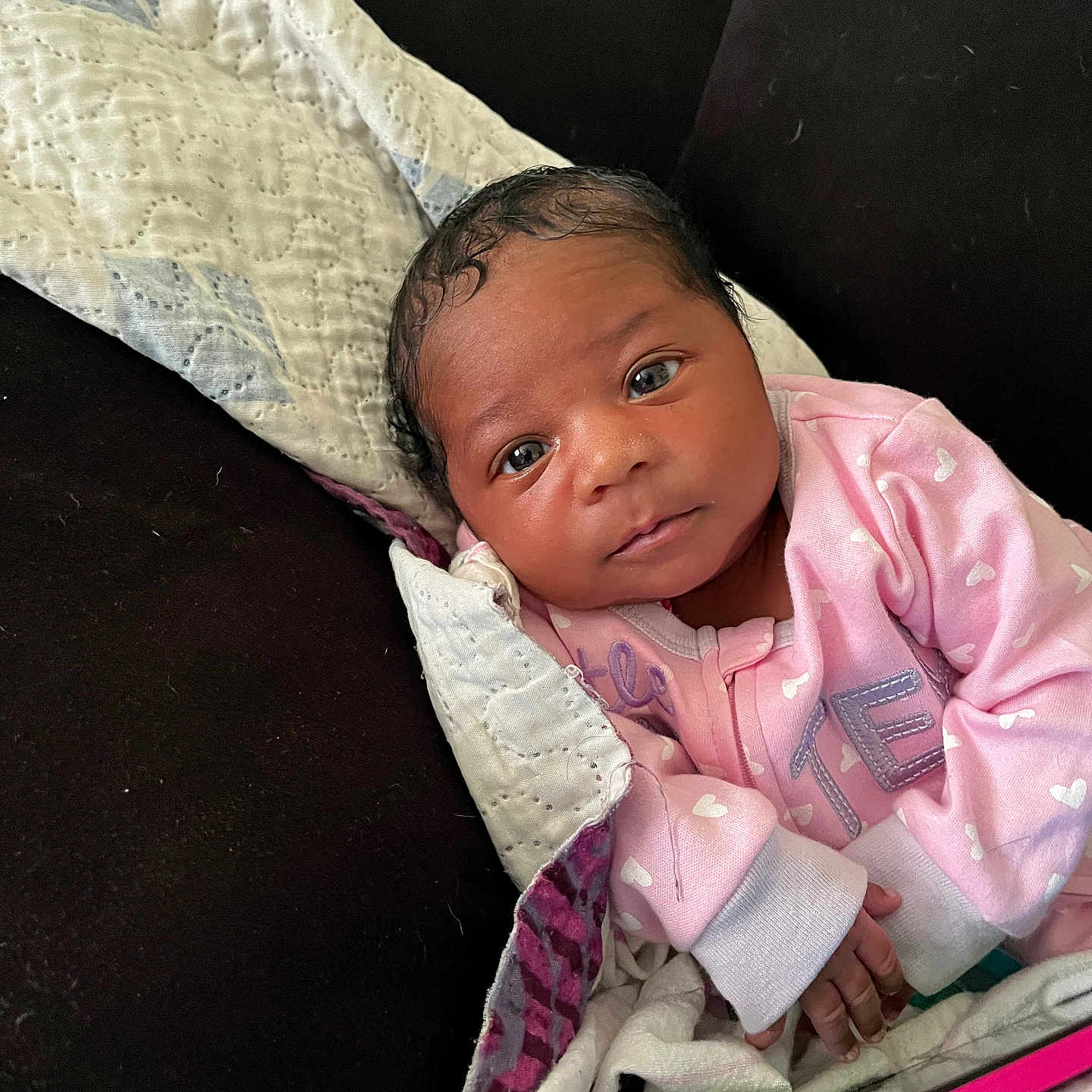 Rayn is registered to the contest to win money with this photo: baby, blanket, couch, cozy, curious, eyes, face, hand, heart_pattern, indoor, infant, newborn, person, phone, pink_clothing, portrait, quilt, resting, skin, soft_lighting