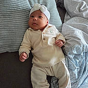 Thays participe au concours pour gagner de l'argent avec cette photo : baby, infant, headband, bow, white_clothing, pillow, blanket, bed, sleepwear, socks, cute, lying_down, indoors, soft_texture, child, small_hands, expression, comfort, resting, young