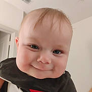 Orien is registered to the contest to win money with this photo: baby, background, black_shirt, cheeks, child, closeup, clothing, cute, door, expression, eyes, face, hair, head, indoor, infant, person, skin, smiling, toddler