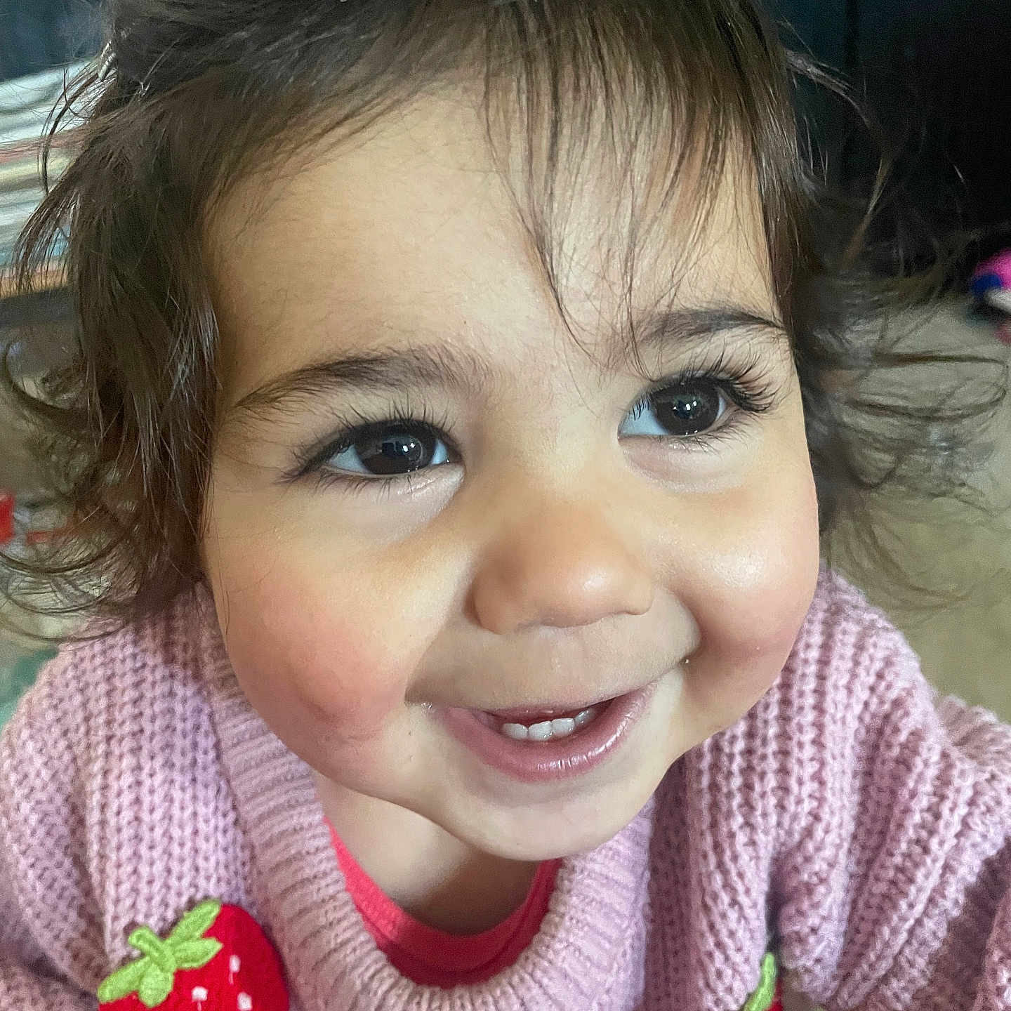 Léïa a rejoint le concours — aidez-le/la à gagner de superbes lots ! baby, child, closeup, clothing, curly_hair, cute, expression, eyes, face, happy, indoor, person, pink, portrait, smiling, strawberry, sweater, toddler, warm, young_child