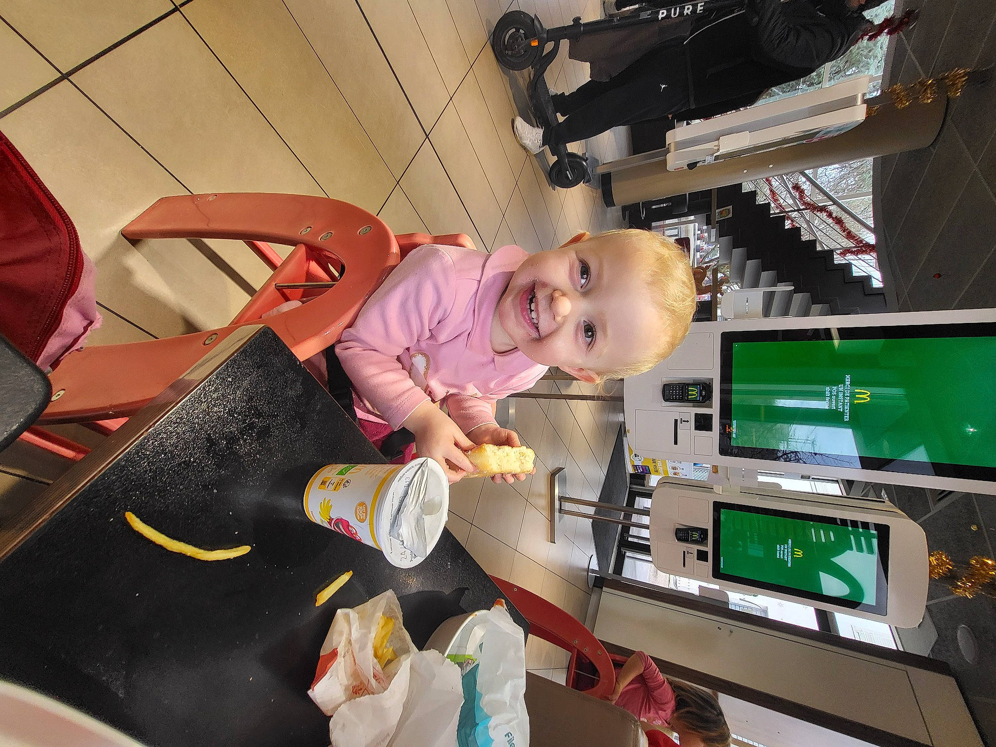 Mila a rejoint le concours — aidez-le/la à gagner de superbes lots ! baby, baby_products, baby_toddler_clothing, child, display_device, fun, joy, machine, person, room, shelf, smile, t_shirt, toddler