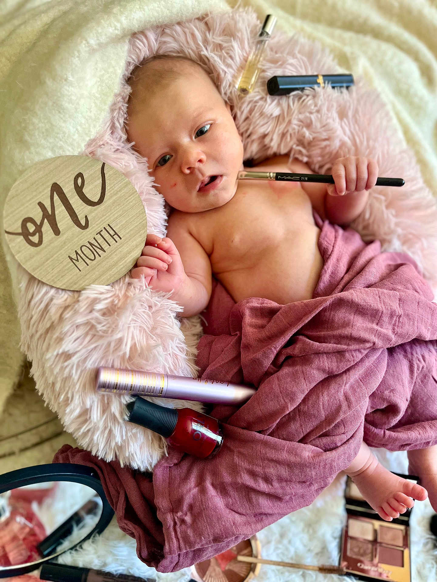 Rosie-Araya joined the competition — help win amazing prizes! baby, infant, one_month, fluffy_cushion, makeup_brush, nail_polish, mascara, eyeshadow_palette, pink_blanket, mauve_cloth, wooden_sign, milestone, cute, portrait, skin, hand, foot, cosmetics, relaxed, indoors