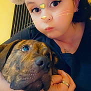 Max participe au concours pour gagner de l'argent avec cette photo : person, dog, animal_filter, selfie, indoor, cuddle, brindle_dog, earring, ring, warm_lighting, black_clothing, closeup, face, hand, whiskers, fuzzy_ears, yellow_background, headband, affection, portrait