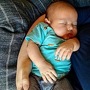 Elmer joined the competition — help win amazing prizes! baby, sleeping, infant, person, arm, hand, clothing, striped_pants, blue_shirt, holding, resting, cute, peaceful, indoor, closeup, comfort, soft, human, portrait, casual