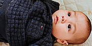 Elmer joined the competition — help win amazing prizes! baby, child, clothing, cute, ear, eyes, fabric, face, hand, head, indoor, infant, lying_down, person, portrait, quilt, skin, sweater, texture, young