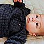 Elmer joined the competition — help win amazing prizes! baby, infant, child, face, eyes, sweater, clothing, quilt, fabric, texture, skin, head, ear, hand, lying_down, portrait, cute, indoor, young, person