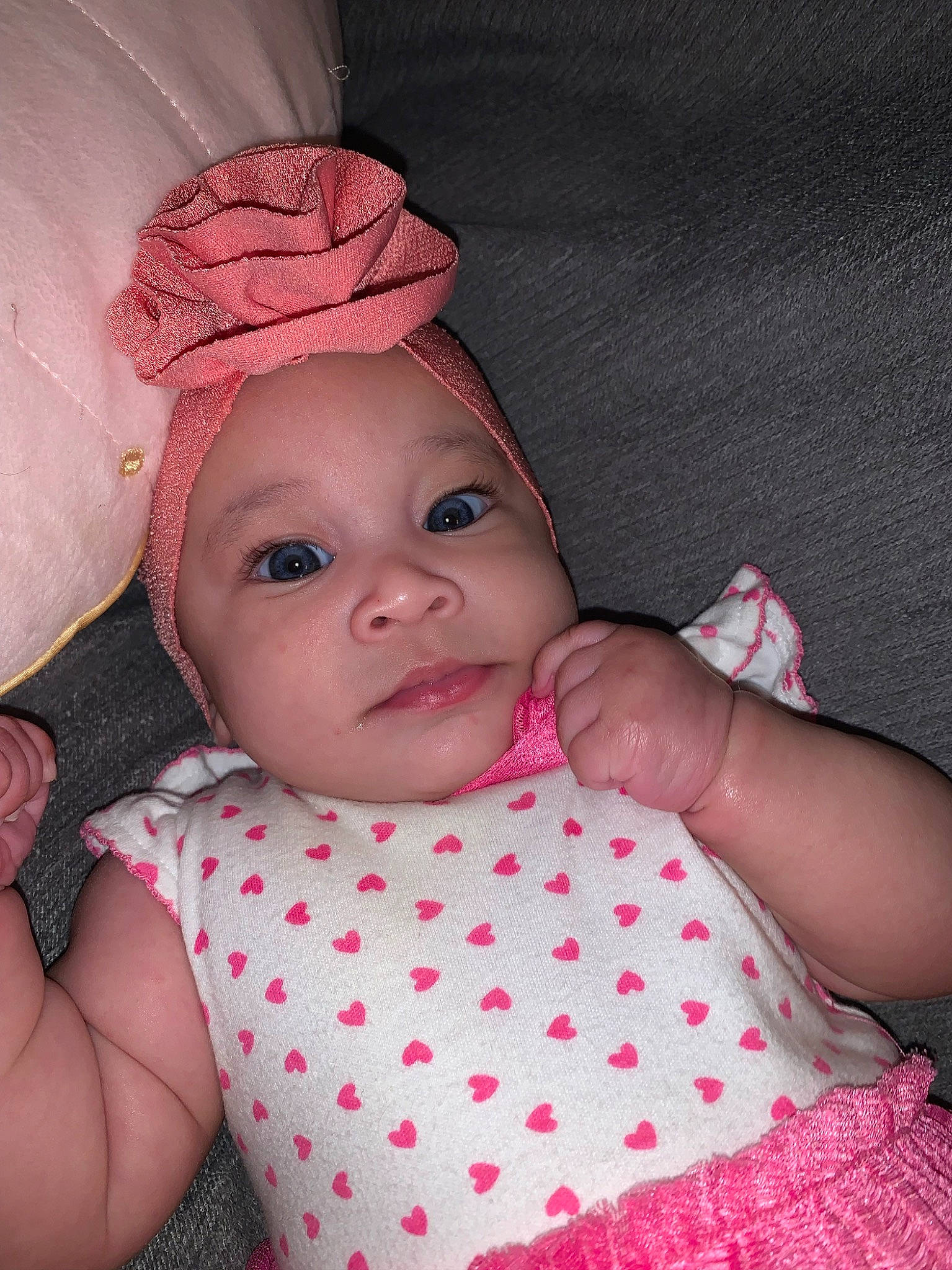 Amarah is registered to the contest to win money with this photo: arm, baby, baby_products, baby_toddler_clothing, cap, cheek, child, dress, eye, face, hand, headgear, headwear, lip, magenta, pattern, person, pink, skin, sleeve