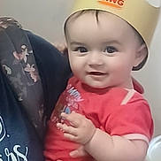 Ariana is registered to the contest to win money with this photo: baby, child, person, crown, burger_king, red_clothing, hand, smile, indoor, adult, holding, face, headwear, cute, infant, portrait, happy, closeup, skin, human
