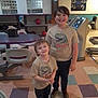 child, children, smiling, tshirt, dinosaur, bowling_alley, bowling_ball, floor, indoor, person, young, casual_clothing, shoes, happy, standing, recreation, leisure, fun, siblings, portrait