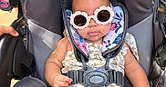 Araceli joined the competition — help win amazing prizes! baby, sunglasses, stroller, child, seatbelt, flower_pattern, clothing, infant, outdoor, person, cute, fashion, summer, accessory, headwear, portrait, sitting, small_child, baby_girl, sunlight