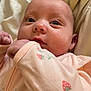 Isolde is registered to the contest to win money with this photo: baby, infant, face, eyes, clothing, onesie, strawberry_print, hand, skin, newborn, portrait, closeup, soft_fabric, cute, sleepwear, child, young, indoors, head, expression