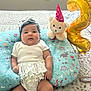 baby, infant, child, cushion, plush_toy, balloon, headband, ruffled_clothing, bed, patterned_fabric, celebration, number_two, cute, indoors, soft_toy, floral_pattern, comfortable, chubby_cheeks, lying_down, decor