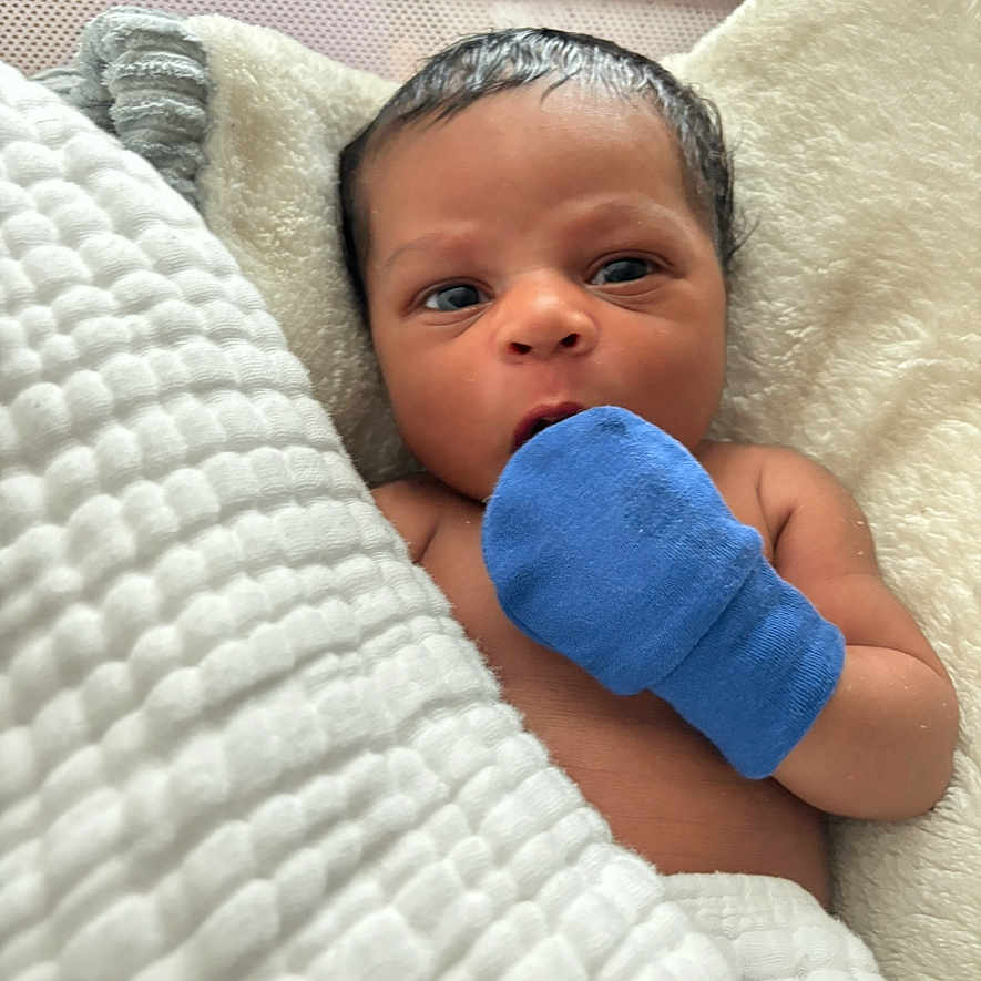 Keanu is registered to the contest to win money with this photo: baby, bed, blanket, bodypart, clothing, cushion, face, finger, furniture, glove, hand, hat, head, homedecor, newborn, person, photography, portrait, quilt, sleeping