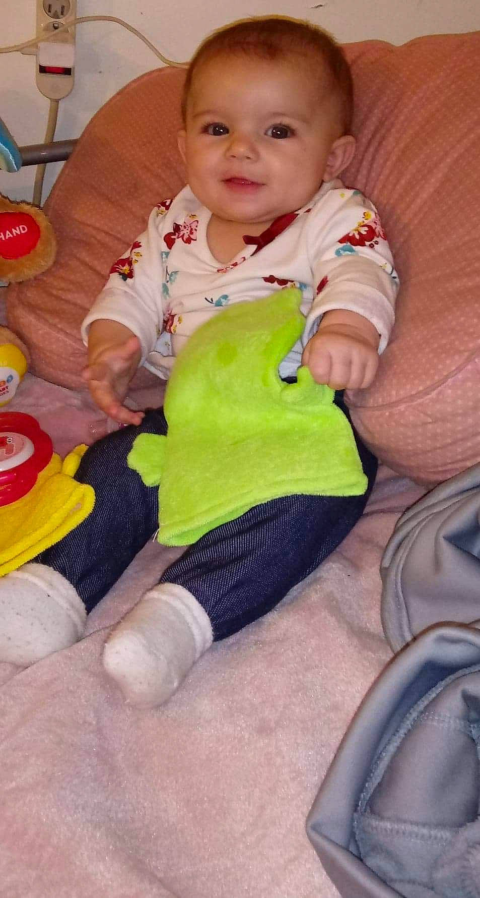 Kaleigha is registered to the contest to win money with this photo: arm, baby_products, child, day, finger, girl, green, hand, infant, leg, material, person, play, product, sitting, skin, textile, toddler, toy, yellow