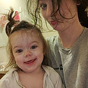 Sophia joined the competition — help win amazing prizes! child, adult, messy_hair, smiling, playful, indoor, casual_clothing, person, face, portrait, family, fun, hair, expression, holding, bathroom, mirror, light, happy, toddler