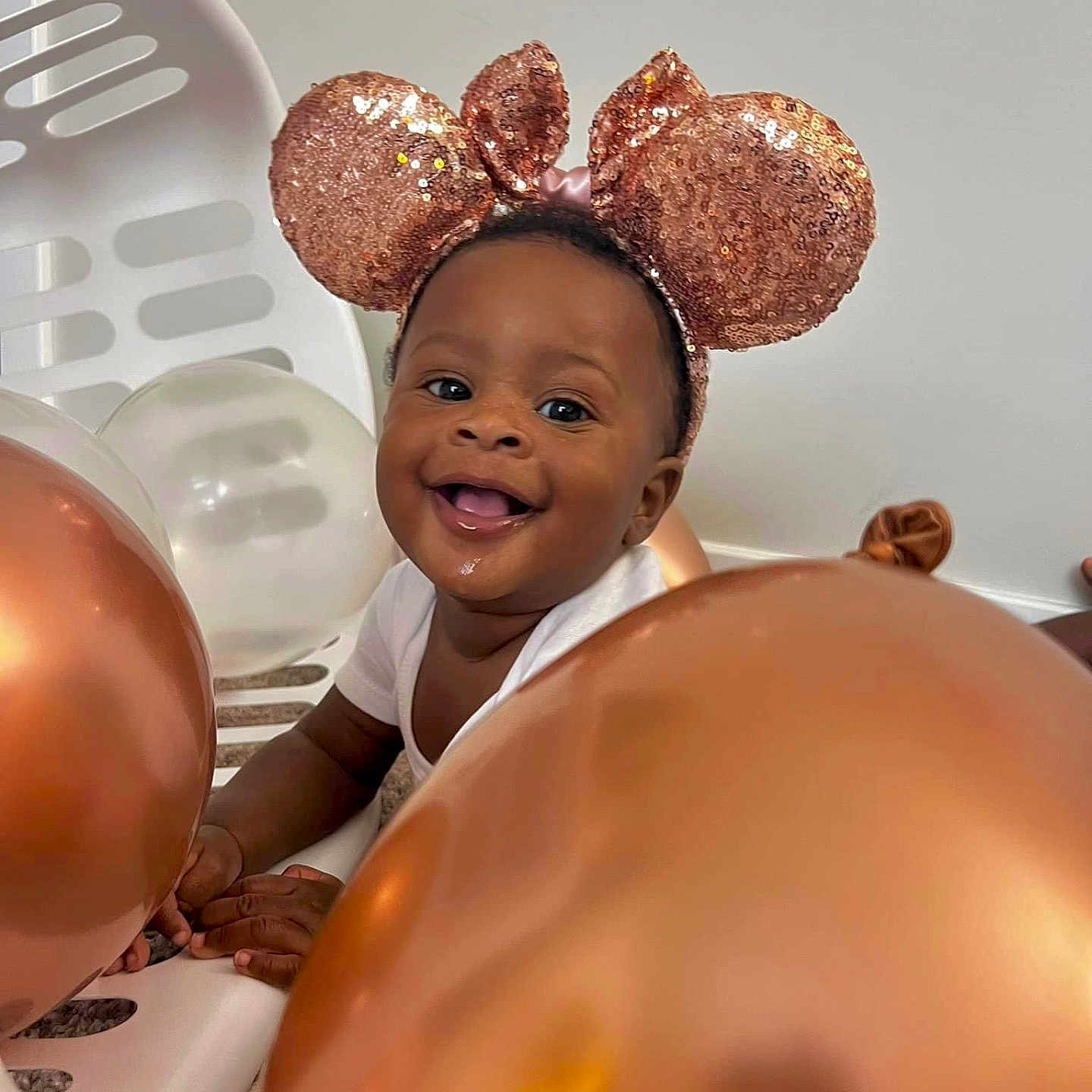Nayaani joined the competition — help win amazing prizes! baby, balloon, celebration, child, cute, decor, face, floor, hands, happy, headband, indoor, infant, mouse_ears, playful, portrait, smiling, sparkly, toy, white_shirt