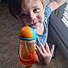 Aidan joined the competition — help win amazing prizes! barefoot, blue, brown_hair, carpet, child, curtains, drink, happy, indoors, orange, plush_toy, portrait, shutters, sippy_cup, smiling, standing, sunlight, toddler, toy, window