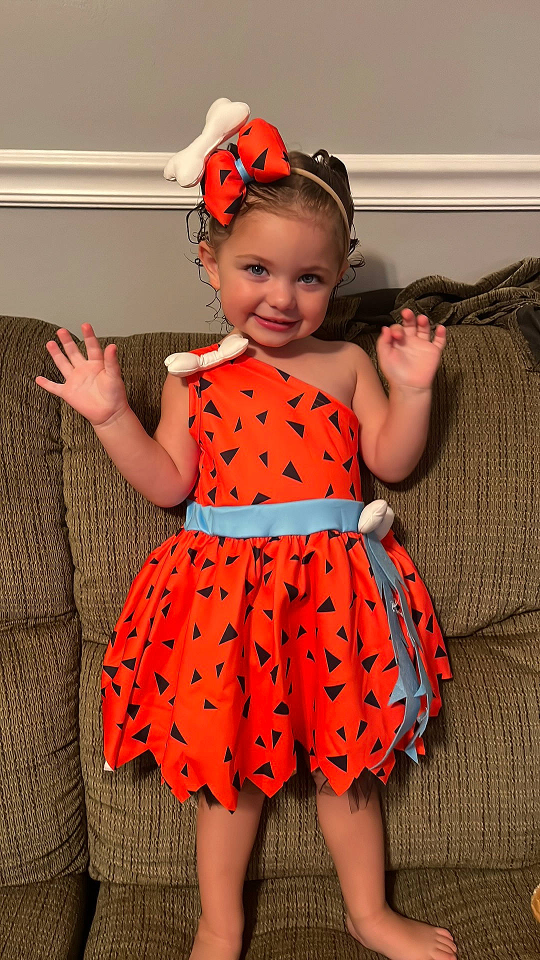 Remi is registered to the contest to win money with this photo: arm, baby_toddler_clothing, child, day_dress, dress, eye, fashion_design, finger, happy, head, headwear, human_body, joy, neck, one_piece_garment, orange, pattern, person, product, sleeve