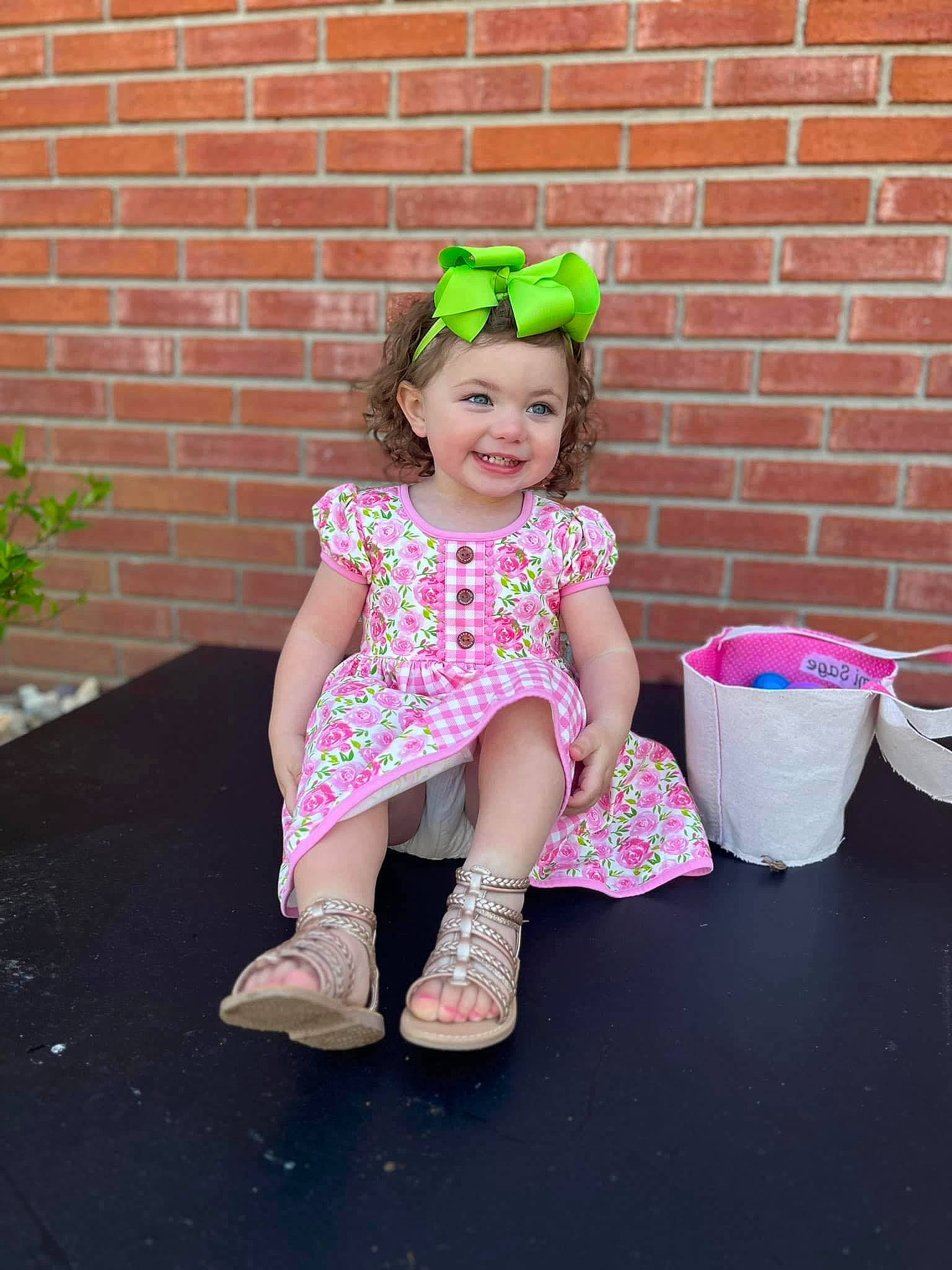 Remi is registered to the contest to win money with this photo: baby_toddler_clothing, brick, child, face, fashion_accessory, fun, grass, happy, head, headwear, human_leg, jewellery, joy, leisure, magenta, pattern, person, pink, plant, sandal