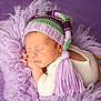 newborn, baby, sleeping, knit_hat, tassel, purple, blanket, soft_texture, cozy, infant, cute, portrait, resting, child, warm_clothing, closeup, peaceful, head, face, hands