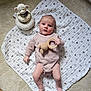 baby, blanket, carpet, child, clothing, face, floor, furniture, hand, head, knitted_toy, person, plush_toy, portrait, toy, wood_floor, infant, cute, lying_down, star_pattern