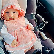 Viviana is registered to the contest to win money with this photo: baby, child, car_seat, pink_dress, bonnet, white_tights, infant, seatbelt, car_interior, cute, portrait, person, sitting, closeup, young_child, clothing, safety, car, adorable, face