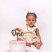 Khaari joined the competition — help win amazing prizes! baby, child, birthday, cake, one_year_old, white_background, dress, lace, pink_frosting, celebration, sitting, foot, necklace, bracelet, cute, portrait, studio_photo, smile, young, party
