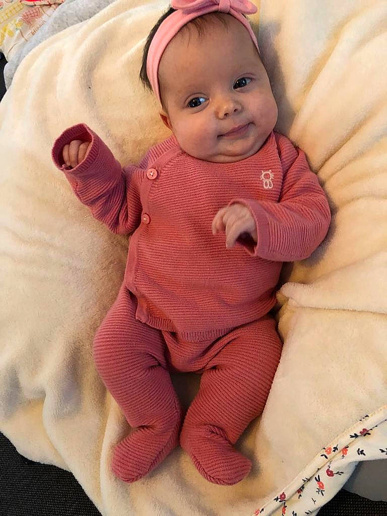 Hiba participe au concours pour gagner de l'argent avec cette photo : arm, baby, baby_toddler_clothing, cheek, chin, comfort, eye, face, hand, happy, head, lip, nose, person, pink, skin, sleeve, smile, textile, toddler