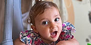 Ghevorchean Suzanna is registered to the contest to win money with this photo: baby, child, cute, smiling, playing, curly_hair, floral_dress, indoors, nursery, toy, hand, face, expression, grip, person, portrait, bright, happy, infant, colorful