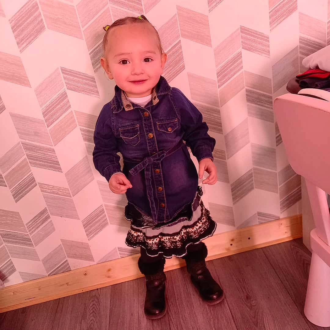 Nawel participe au concours pour gagner de l'argent avec cette photo : baby, baby_toddler_clothing, child, collar, fashion_design, flooring, happy, jacket, joy, knee, leg, magenta, pattern, person, pink, purple, red, sleeve, smile, standing