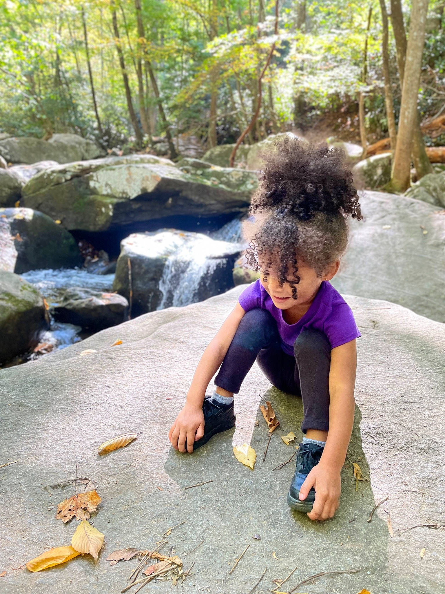 Ryan is registered to the contest to win money with this photo: biome, body_of_water, botany, grass, leaf, leg, leisure, mammal, natural_environment, nature, people_in_nature, person, plant, shoe, sneakers, terrestrial_plant, tree, vertebrate, water, watercourse