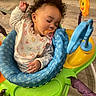 Cyenna is registered to the contest to win money with this photo: baby, sleeping, pacifier, bib, curly_hair, baby_walker, toy, floor, indoor, child, peaceful, colorful, plastic, seat, cushion, clothing, person, infant, cute, relaxed