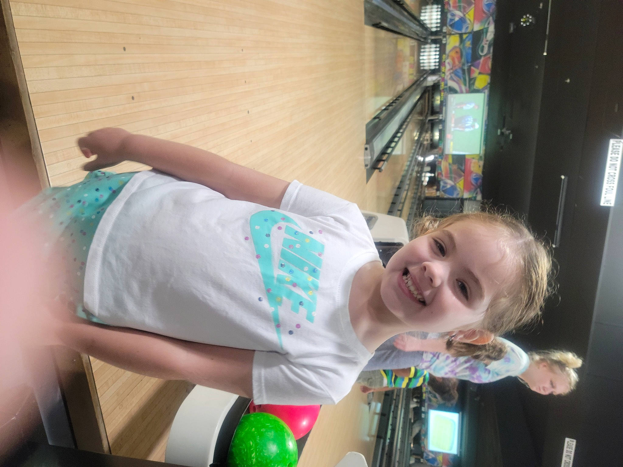Riley joined the competition — help win amazing prizes! ball, bowling_equipment, child, elbow, event, fun, happy, human_leg, joy, leisure, person, play, recreation, room, shelf, smile, sports_toy, t_shirt, thigh, toddler