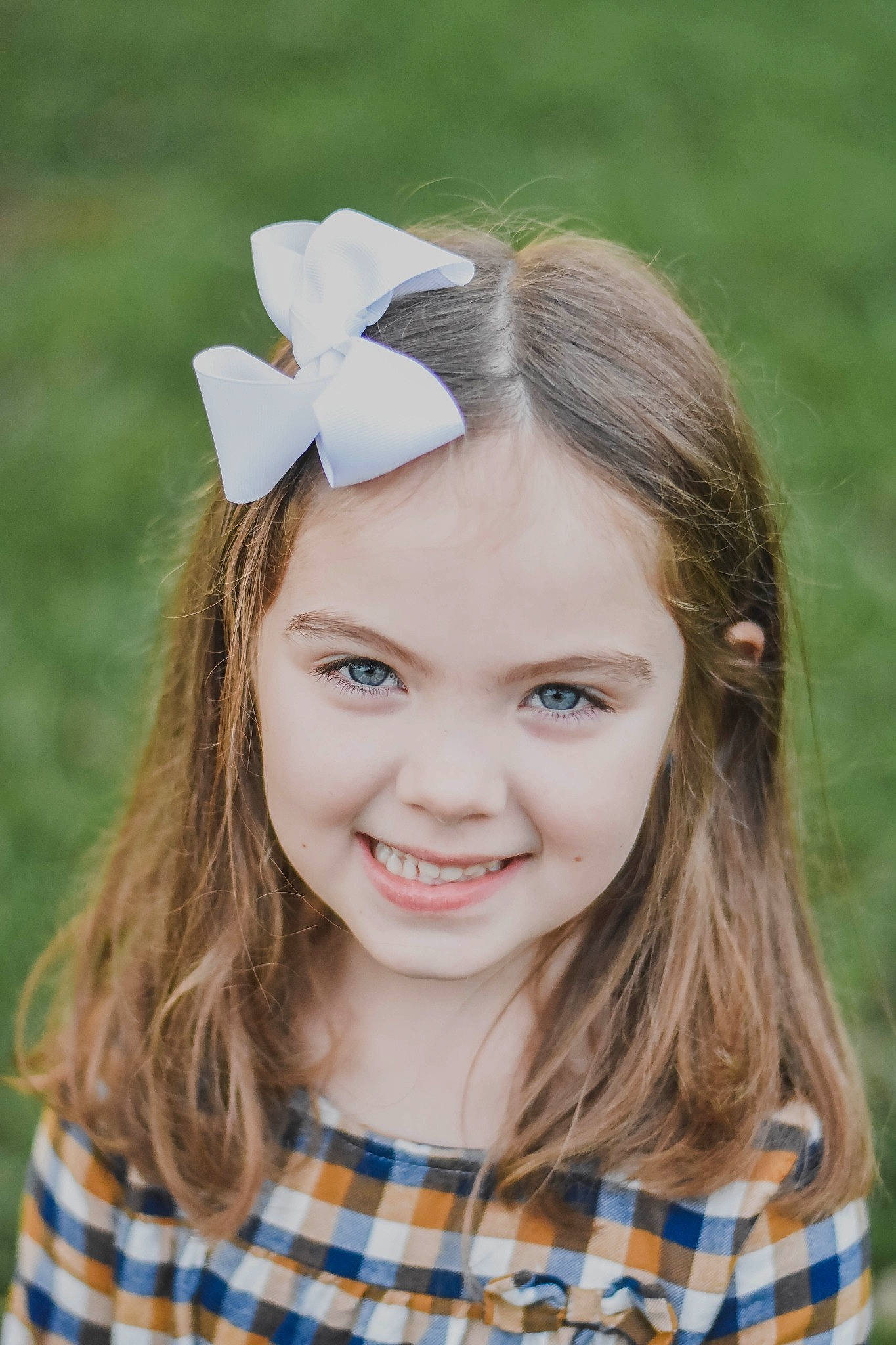 Riley is registered to the contest to win money with this photo: clothing, eye, eyelash, face, flash_photography, flower, grass, happy, hat, head, headgear, iris, joy, lip, people_in_nature, person, petal, plaid, plant, skin