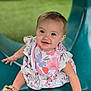 Emma is registered to the contest to win money with this photo: baby, child, smiling, slide, outdoor, playground, dress, bib, footwear, sandals, grass, happy, person, portrait, cute, sitting, young, skin, head, hand
