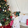 barefoot, carpet, celebration, child, christmas_tree, curious, decorations, exploring, festive, green_bow, holiday, holiday_decor, indoor, ornament, presents, red_ornament, seasonal, toddler, white_coat, young_child