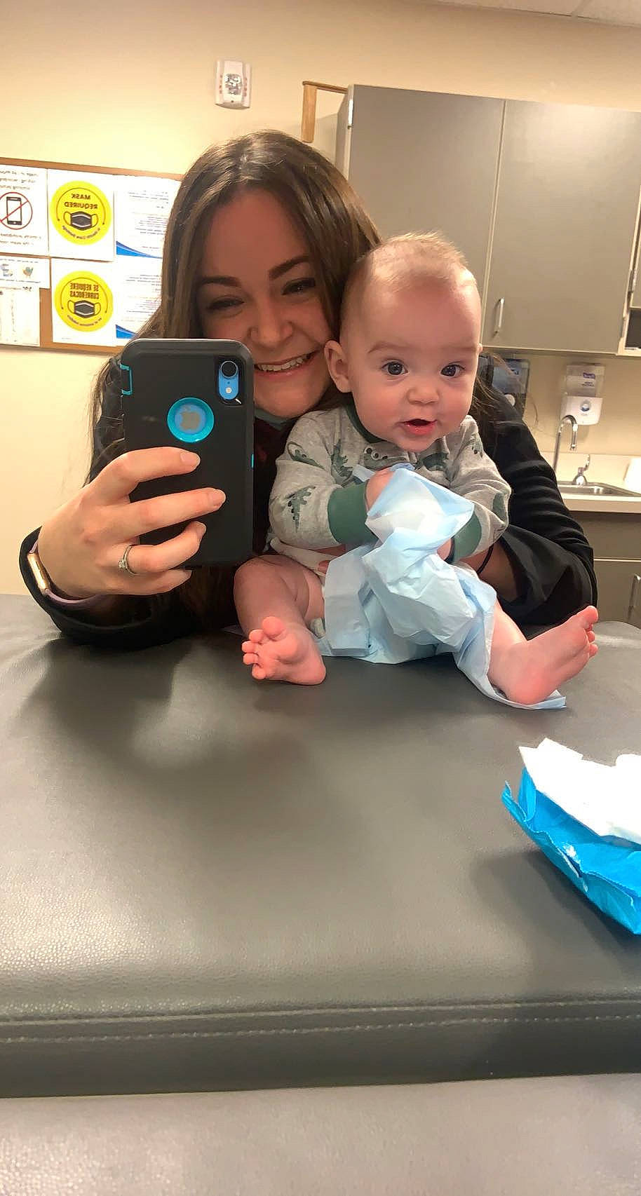 Jacson is registered to the contest to win money with this photo: arm, baby, child, communication_device, electronic_device, face, finger, fun, gadget, gesture, hand, happy, head, joy, mouth, person, sitting, skin, smile, t_shirt