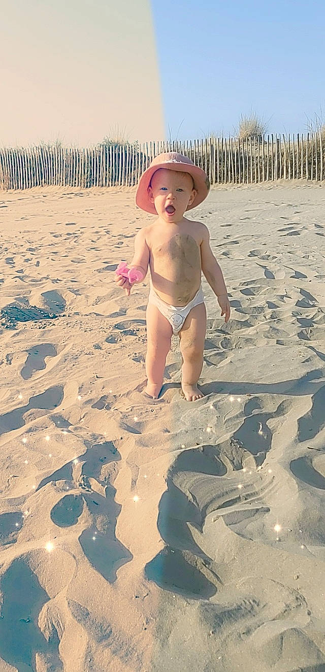 Mylaïa participe au concours pour gagner de l'argent avec cette photo : abdomen, art, baby, barechested, beach, chest, cloud, fun, happy, hat, human_leg, landscape, people_in_nature, people_on_beach, person, sand, shore, shorts, sky, toddler