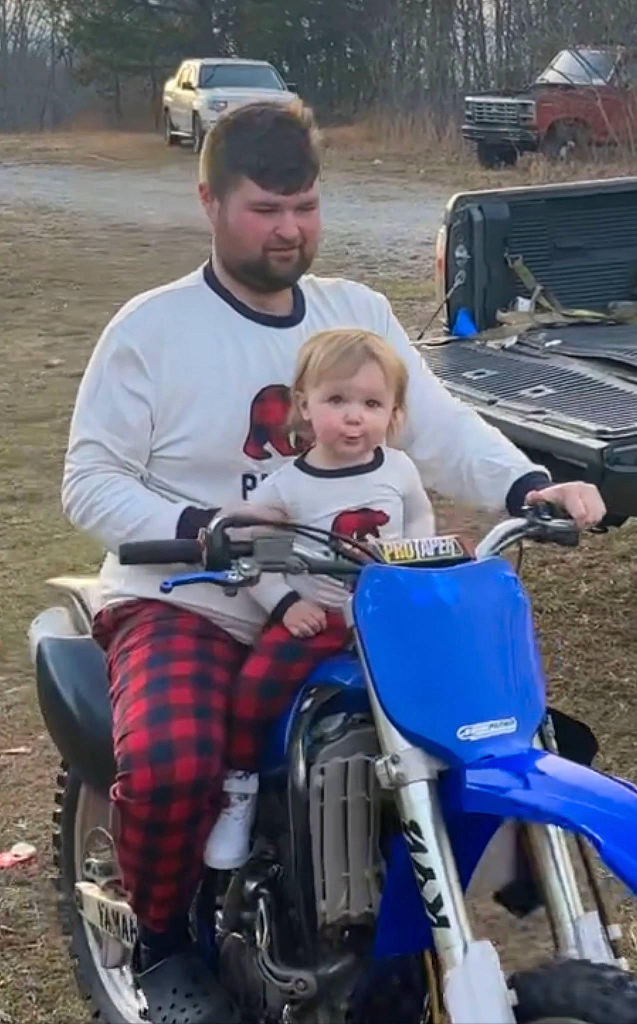 Raelynn is registered to the contest to win money with this photo: auto_part, automotive_exterior, automotive_tire, car, child, fun, grass, land_vehicle, lap, leg, motor_vehicle, person, recreation, sitting, sneakers, tire, toddler, tree, truck, vehicle