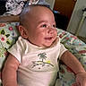 Miles joined the competition — help win amazing prizes! baby, smiling, infant, onesie, cushion, floral_pattern, indoor, happy, cute, child, person, portrait, skin, head, arm, clothing, seated, cozy, expression, toothy_grin