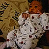 James joined the competition — help win amazing prizes! baby, infant, onesie, clothing, sports_pattern, pillow, text, eiffel_tower, love, bonjour, heart, face, hands, feet, blanket, indoor, child, person, cute, cozy