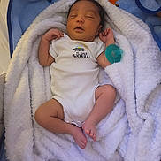 James is registered to the contest to win money with this photo: baby, newborn, sleeping, blanket, white, blue, pacifier, onesie, clothing, infant, cute, cozy, soft, resting, child, person, indoors, portrait, peaceful, wrapped